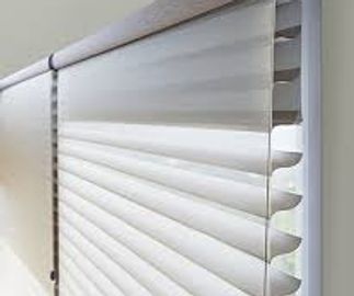 Close-up of white horizontal window blinds in a room.
