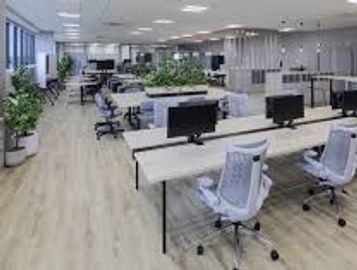Spacious modern office with desks, computers, and ergonomic chairs.