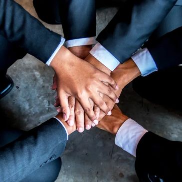 Hands stacked together symbolizing teamwork.