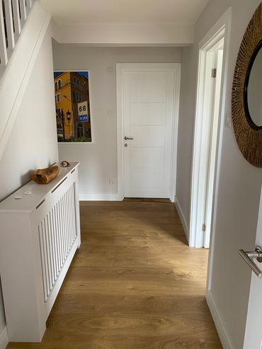 hallway with white table and framed painting with round mirror 