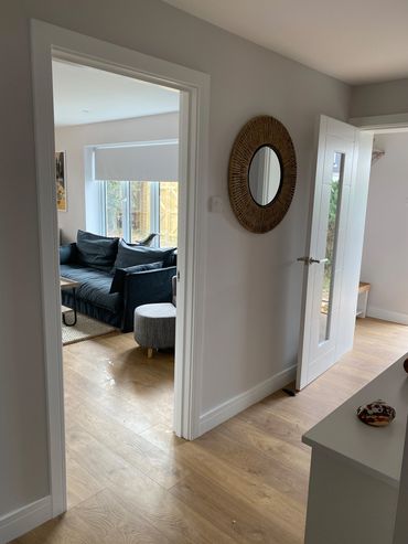 hallway with couch and round mirror