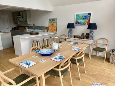 dining room with long table, blue cutlery and bowl