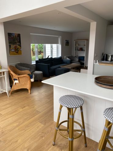 white kitchen with island and wooden floor