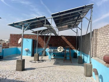 Solar panels installed on a rooftop under clear blue sky.