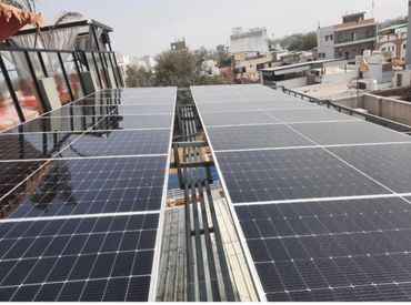 Solar panels installed on a rooftop in an urban area.