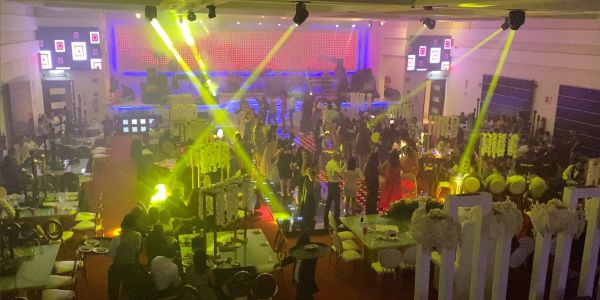 A vibrant indoor event with colorful lights and guests mingling.