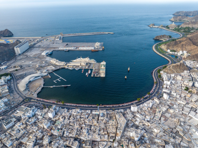 A coastal city with a harbor and winding road along the shore.