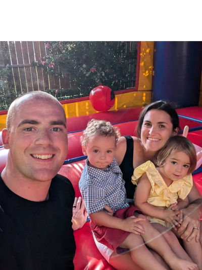 A happy family of four enjoying time together in a colorful bounce house.