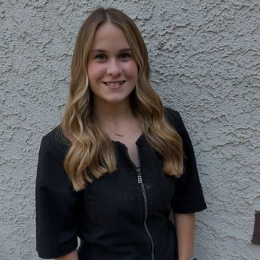 Smiling woman with long blonde hair in a black top.