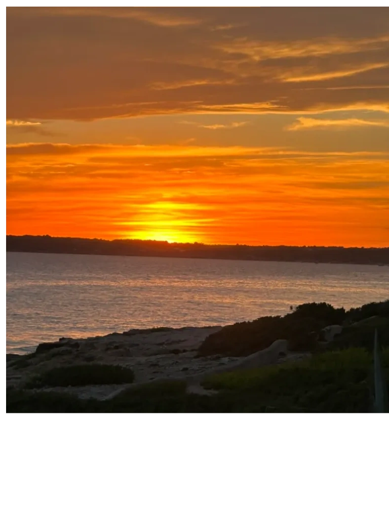 Sunset over a calm coastal shoreline.