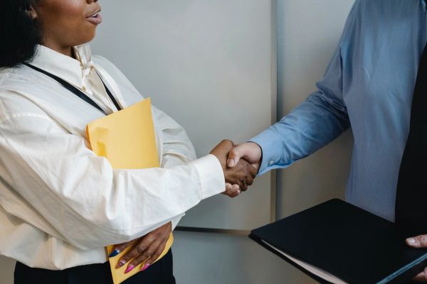 Customer service representative shaking client's hand.