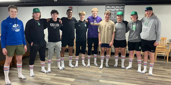 Group of young men in matching striped socks posing indoors.