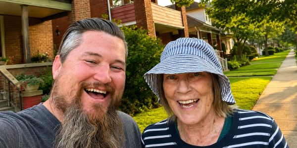 Happy man and woman outside smiling for a selfie.