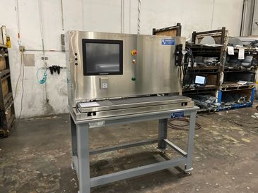 Industrial machine with touchscreen control in a factory setting.