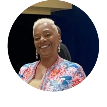 Smiling woman with short blonde hair wearing a floral jacket.
