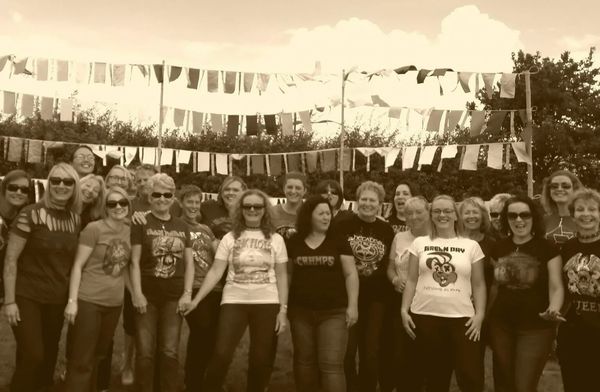 Vocal infinity together at CarFest. Many are wearing pop and rock graphic T‑shirts.