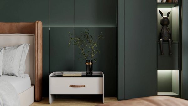 Modern bedroom corner with a bedside table, minimalist decor, and dark green wall panels.