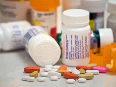 multiple prescription drug bottles and pills on the table