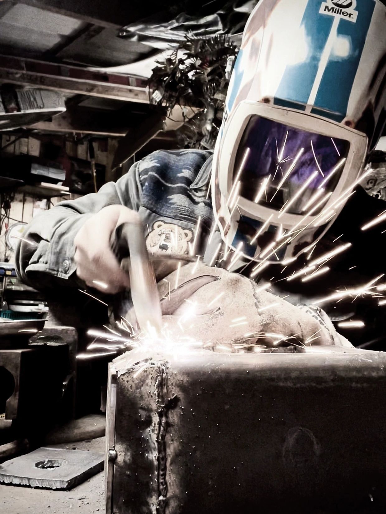 man welding together parts of the statues