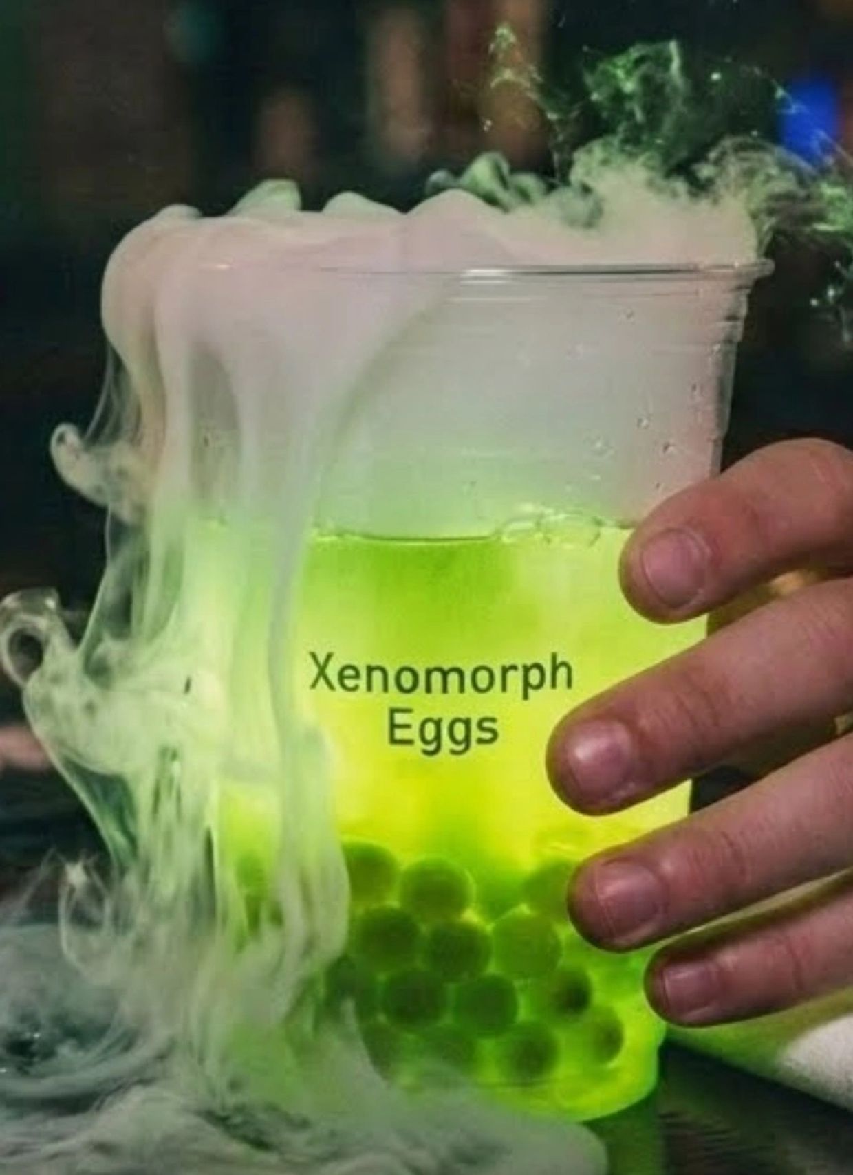 Glowing green drink with fog labeled 'Xenomorph Eggs'
