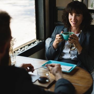 Two people having coffee and a conversation in a cozy cafe.
