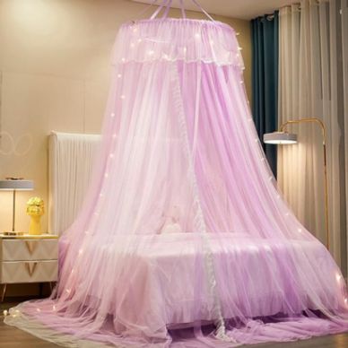 A dreamy pink canopy bed with fairy lights in a cozy bedroom.