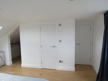Walk-in wardrobe opening in loft room with two doors