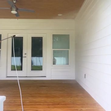 Pressure washing a wooden deck to reveal its natural color.