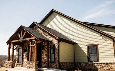 Modern house with stone and wood exterior under a clear sky.