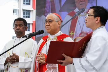 Religious leaders conducting a ceremony with a microphone and holy book.