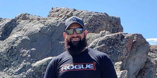 John wearing his JG Bison hat in front of a rock outcropping in the Big Horn Mountains.