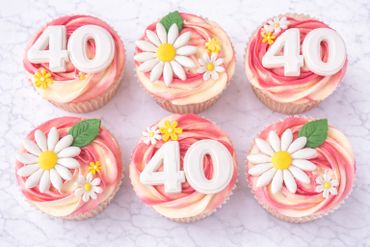 Pink and white swirl cupcakes decorated with daisies and number 40 toppers.