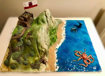 A detailed diorama of a coastal castle, mountain, and sea with a giant octopus figure.