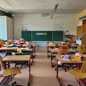 Empty classroom with neat desks and learning materials.