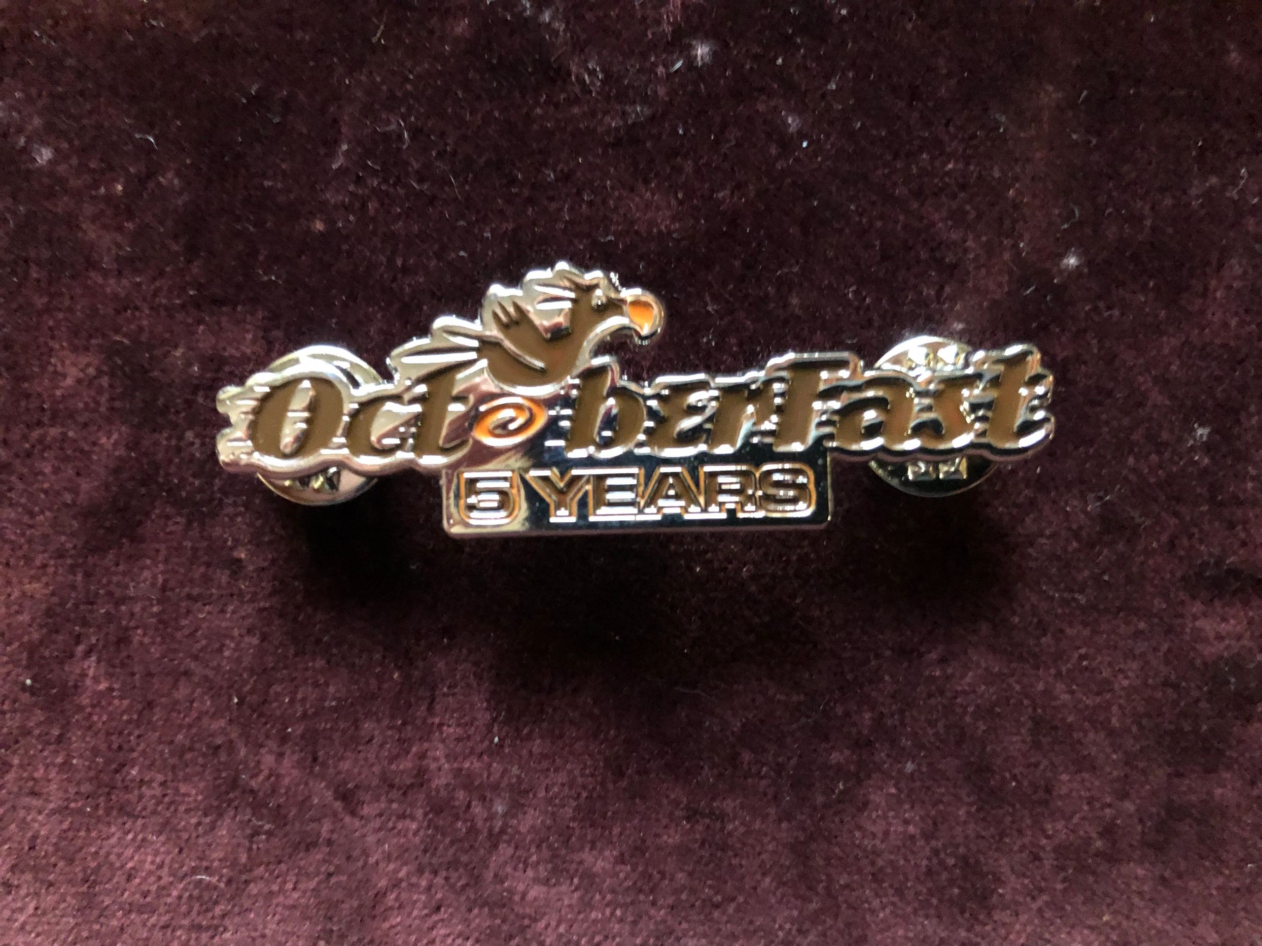 A shiny pin commemorating 5 years of Oktoberfast.
