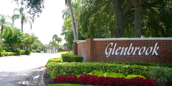 Glenbrook entrance marked by a brick wall and lush landscaping.