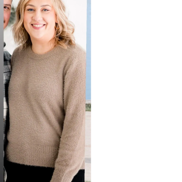 Smiling woman in beige sweater.