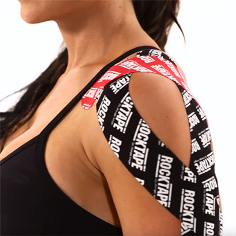 Shoulder with black and red kinesiology tape applied.