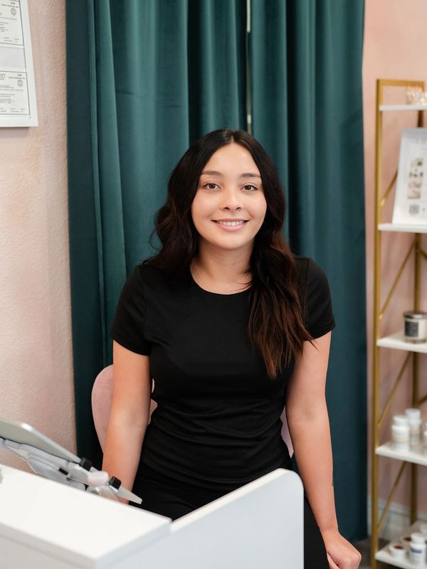 Young woman smiling indoors at a desk.