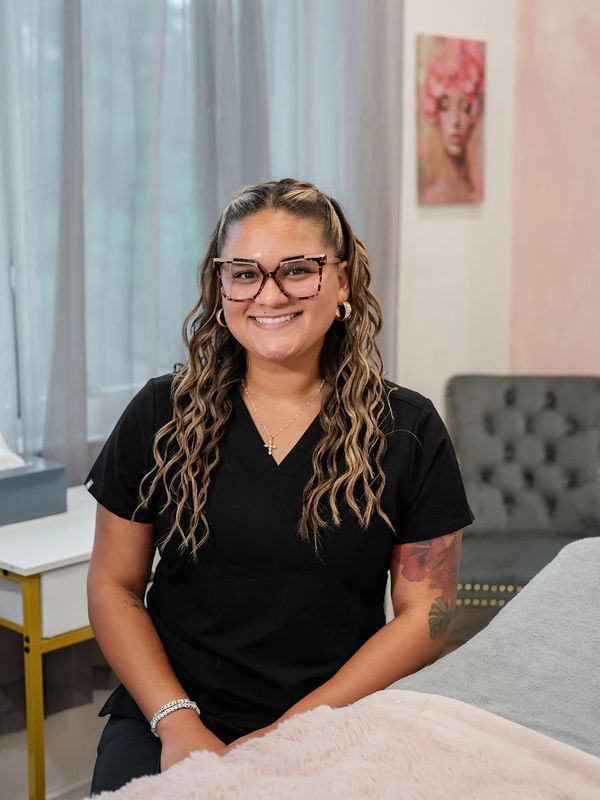 Woman with glasses smiling indoors.