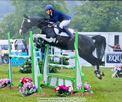 Man jumping horse over a jump at Bramham horse trails.
