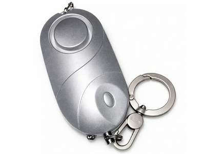 Compact silver personal alarm keychain with a button and clip.