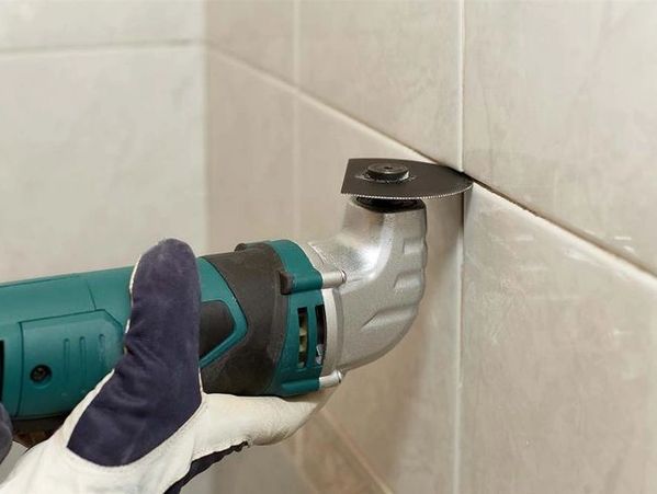 illawarra caulking co Old wall tile grout being cut out in preparation for regrouting in Wollongong