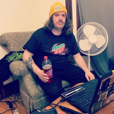 A co-host of a hardcore punk podcast, drinking Mountain Dew Code Red and wearing Mountain Dew shirt