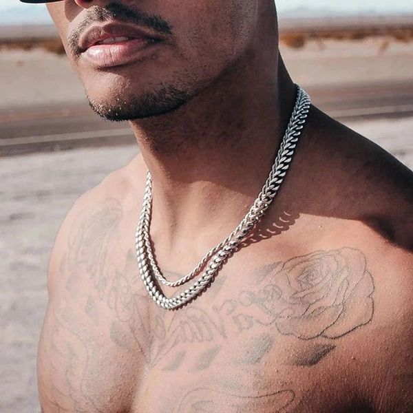 a man wearing a silver rope chain and cuban link chain