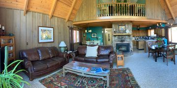 Living area with couches, fireplace and dining in the background