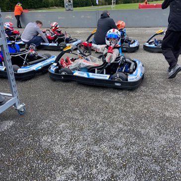 People preparing for a go-kart race on a track.