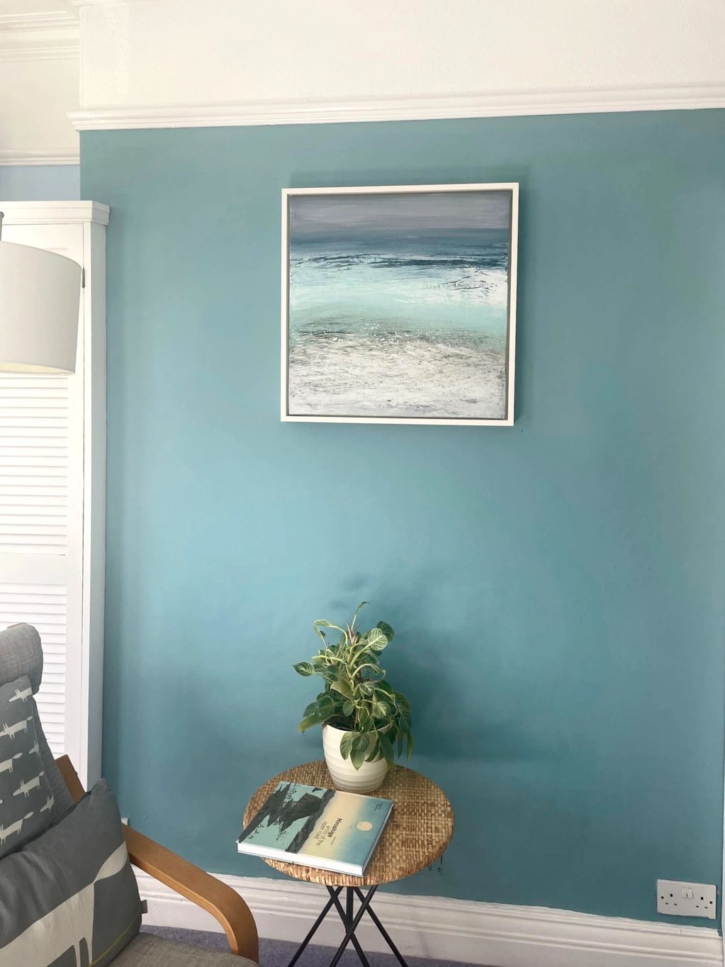 A beautiful painting of the coastal colours of St Ives, framed in white of a blue wall