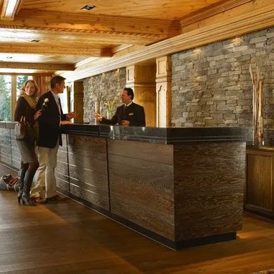 Hotel reception with guests and a staff member.
