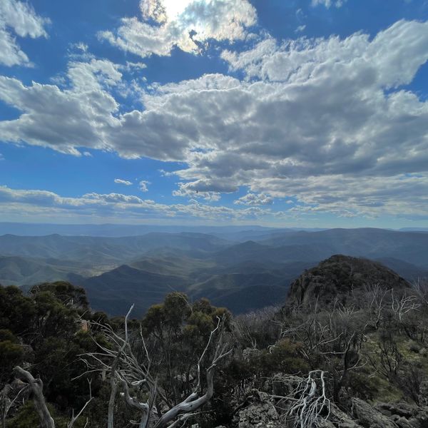 Mountain landscape with dramatic clouds and sunlight breaking through.
